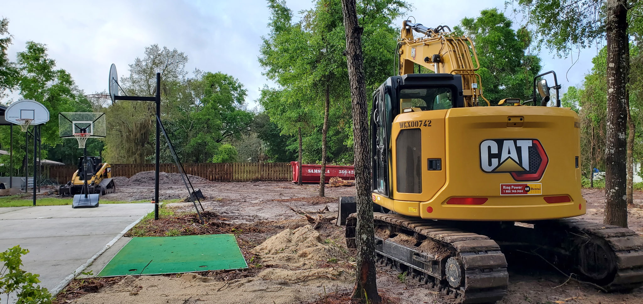 Land clearing behind a home with the basketball court protected