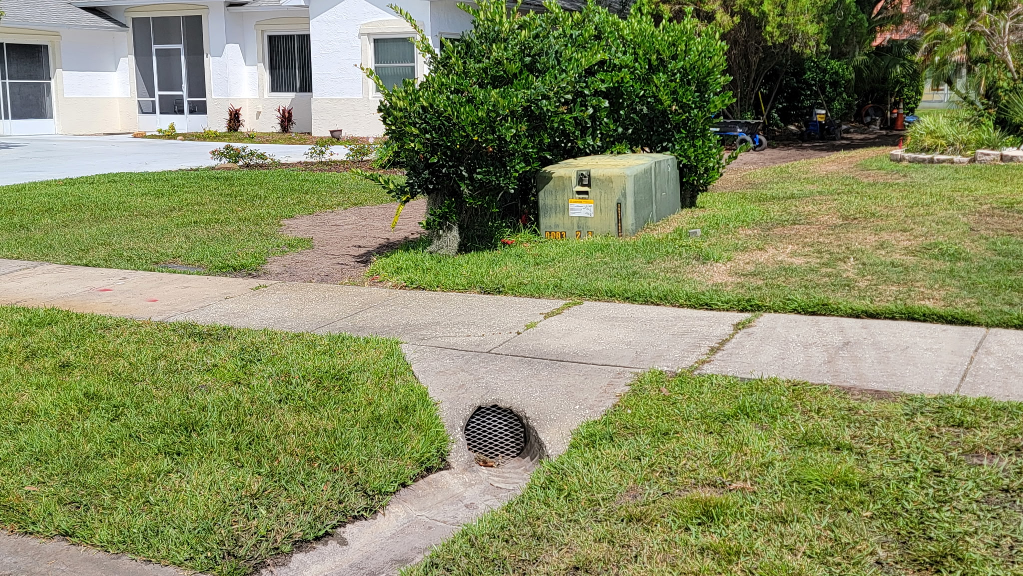 Finished drainage catch basin grate installed in a front yard