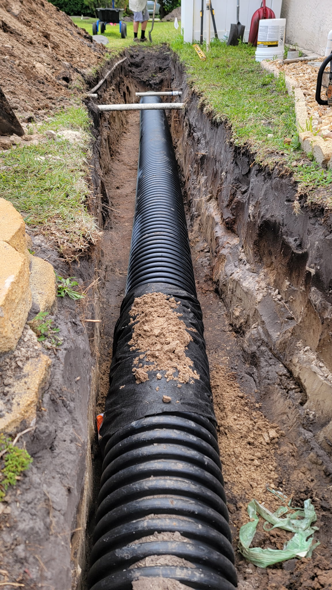 Stormwater drain pipe being laid in a trench before backfill