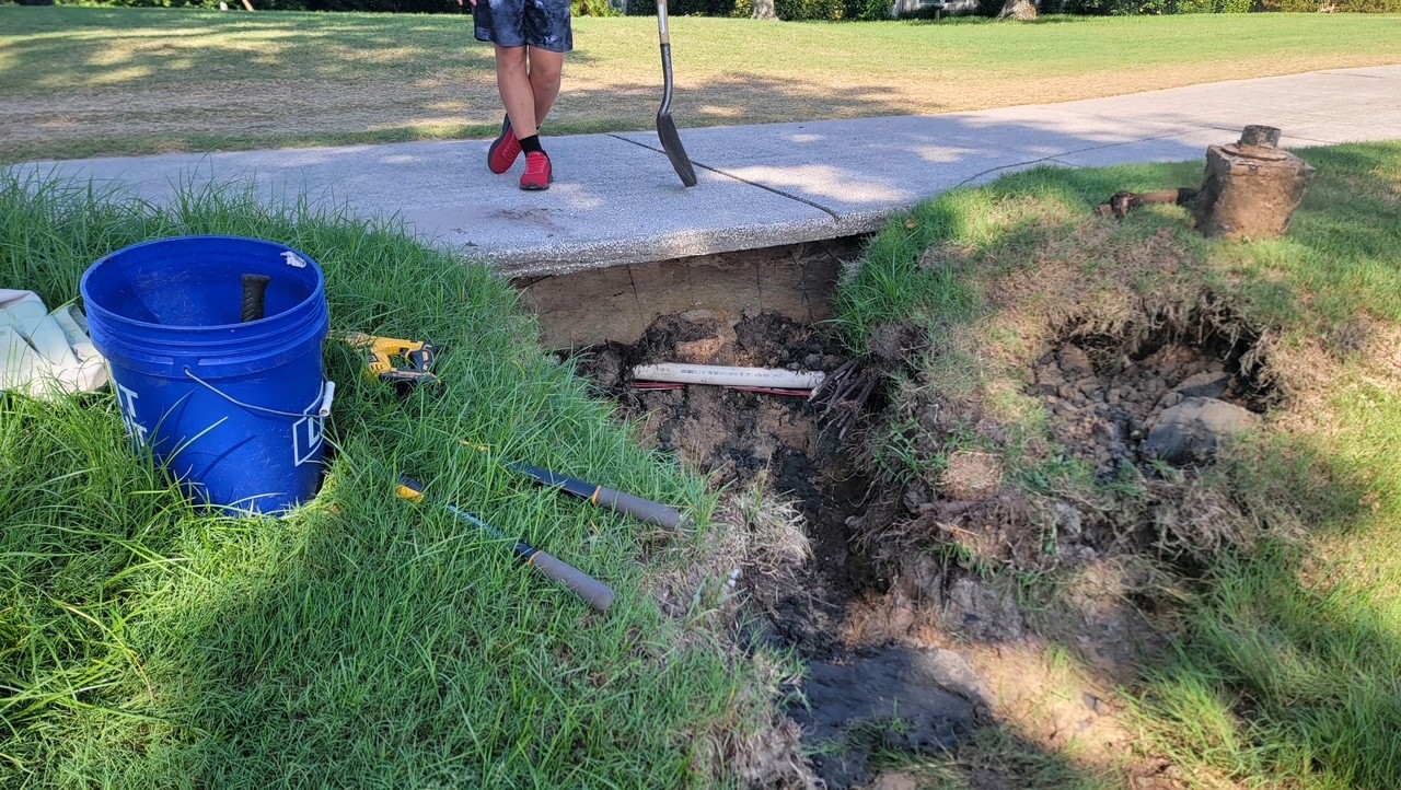 Repairing an irrigation line along a golf course cart path