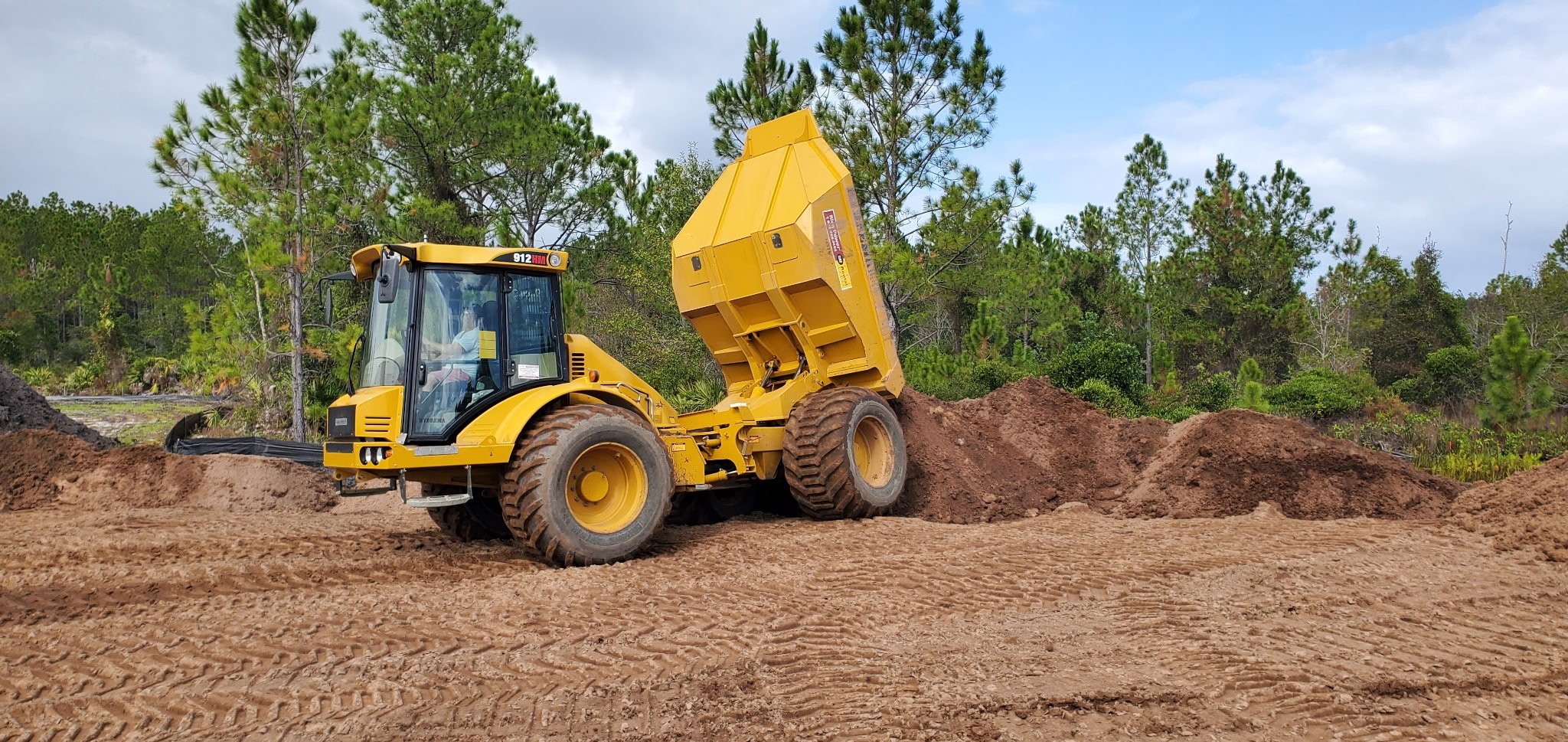 Excavator shaping the banks of a new backyard pond in Palm Coast, FL