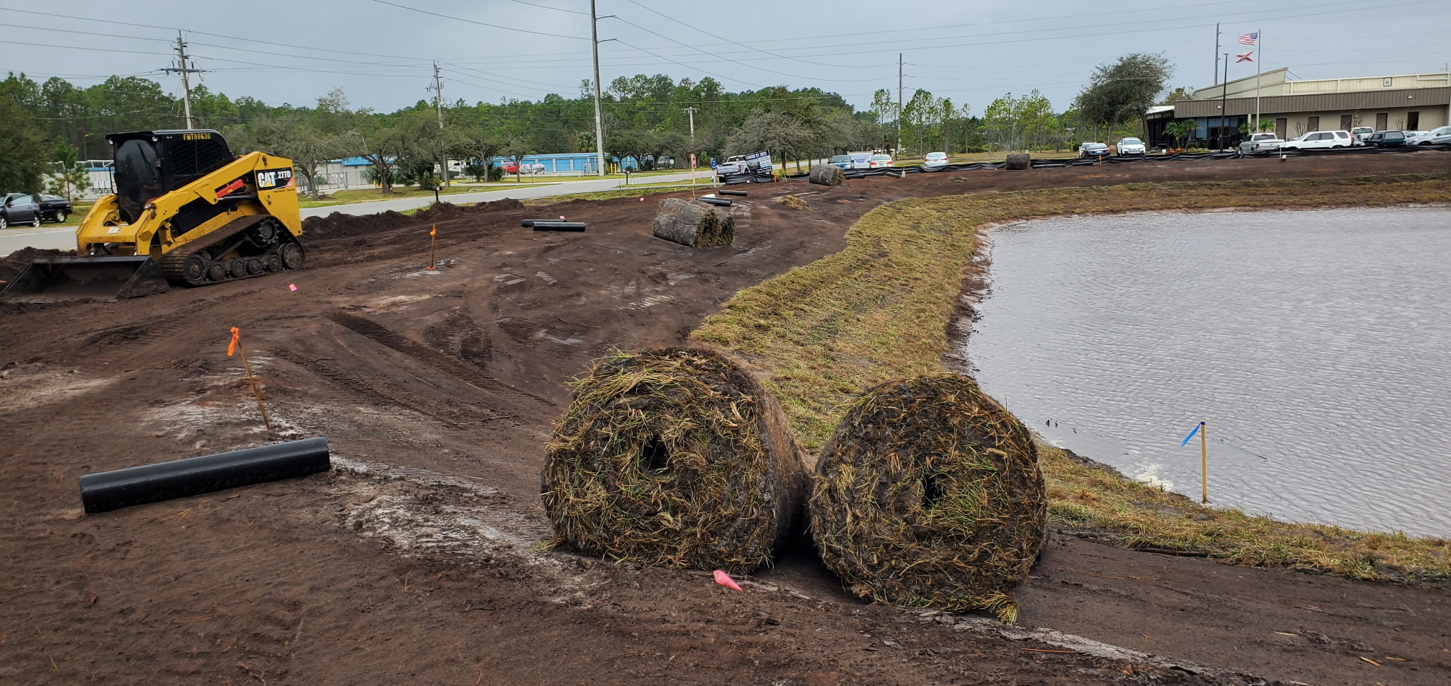 Excavator and dump truck working a large commercial retention basin