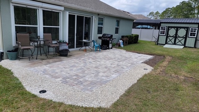 Finished brick paver patio installation with seating area in a Palm Coast backyard