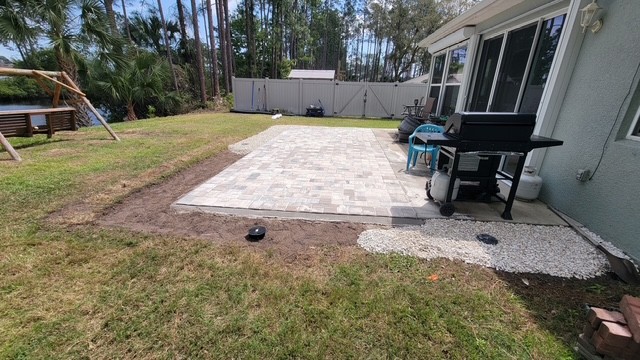 Finished brick paver patio on a waterfront property surrounded by palm trees
