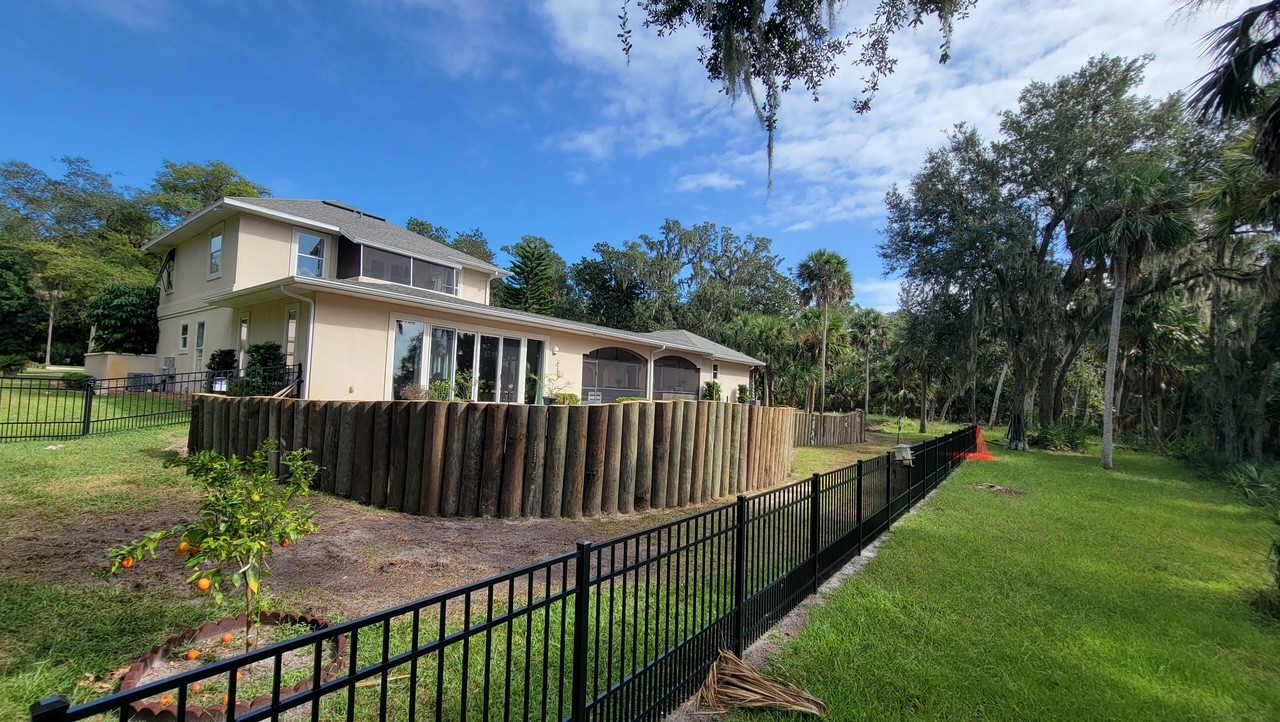 After: finished yard with new aluminum fence and graded landscape bed