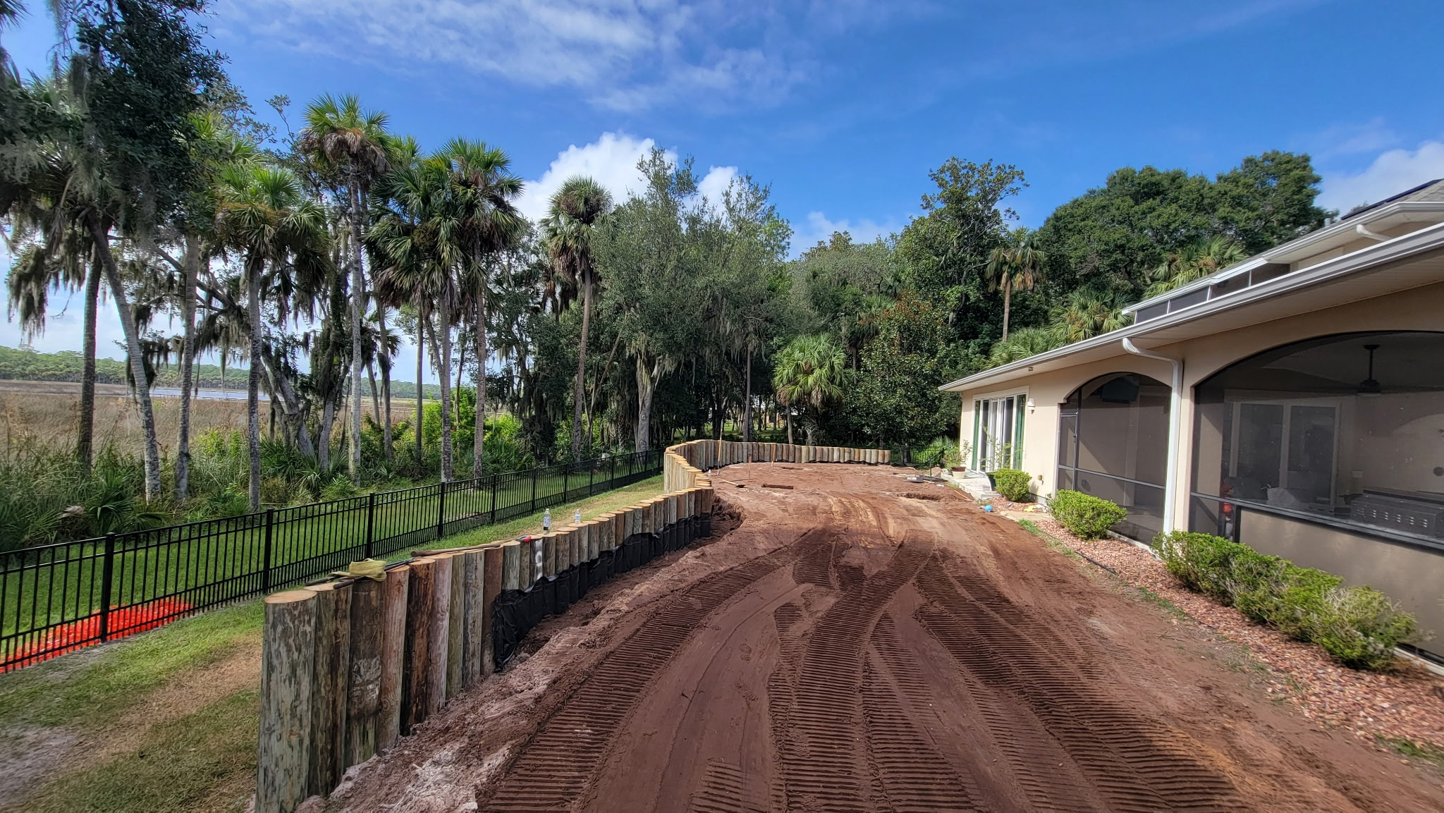 Long timber retaining wall and regraded yard along a waterfront property
